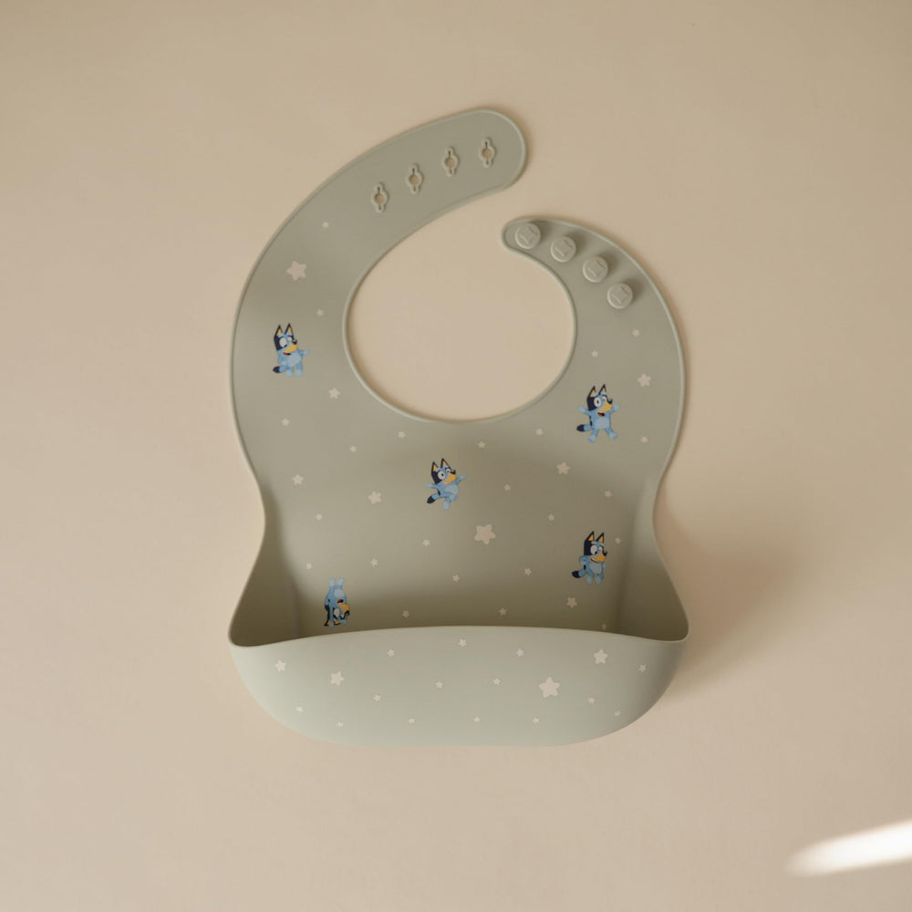Mushie Bluey bib showing adjustable closure that grows with baby