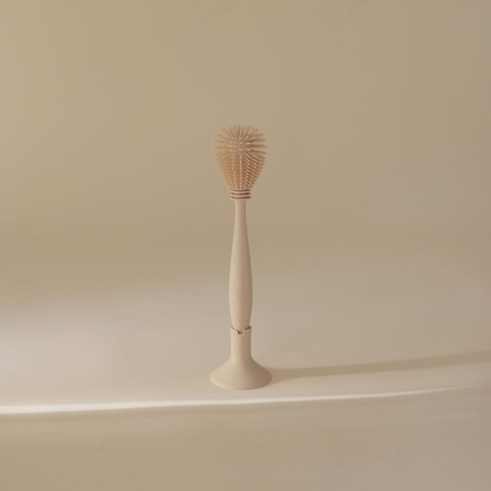 Mushie bottle brush suction base storage keeps counter tidy.