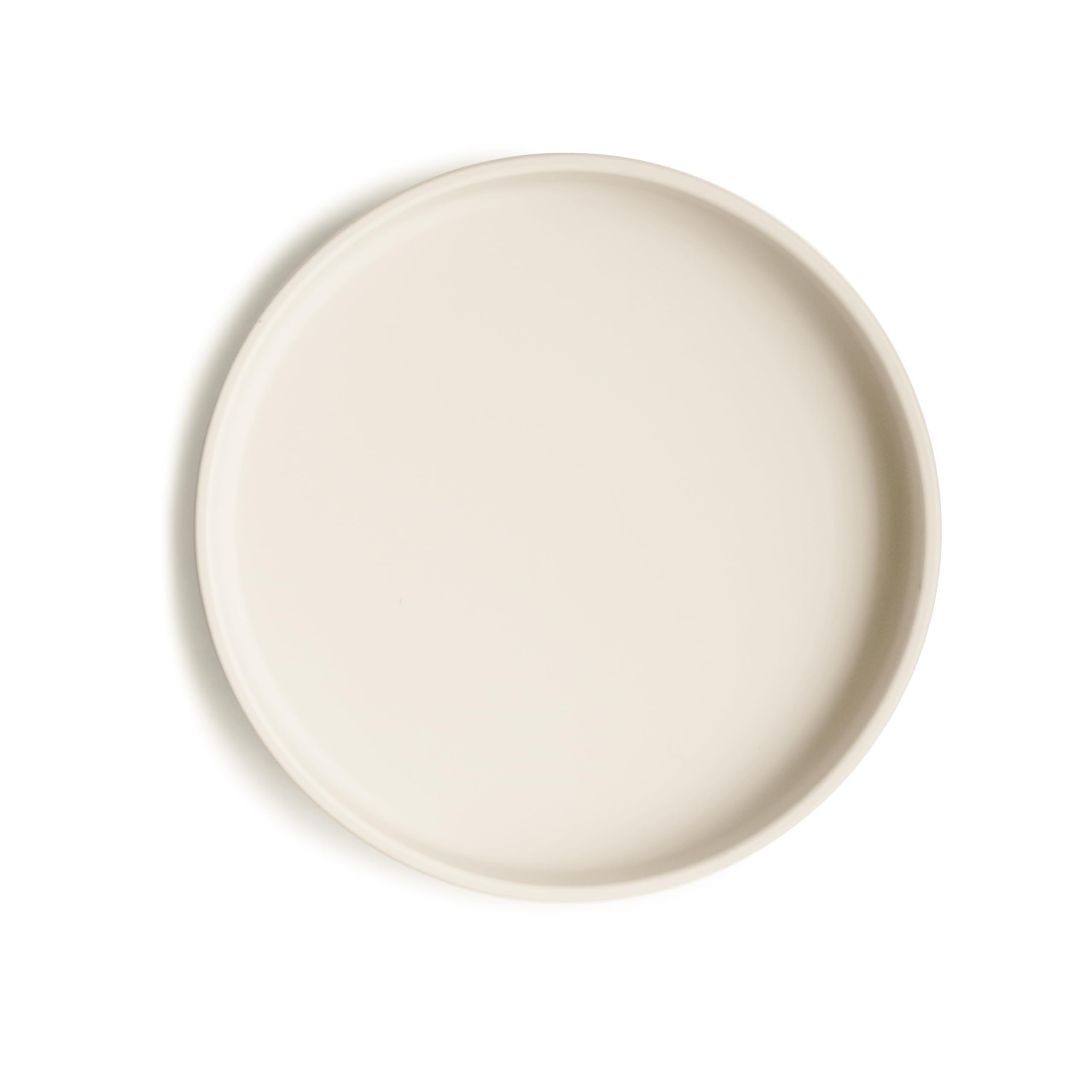Mushie classic silicone suction plate ivory on table shows secure grip for mess-free meals.