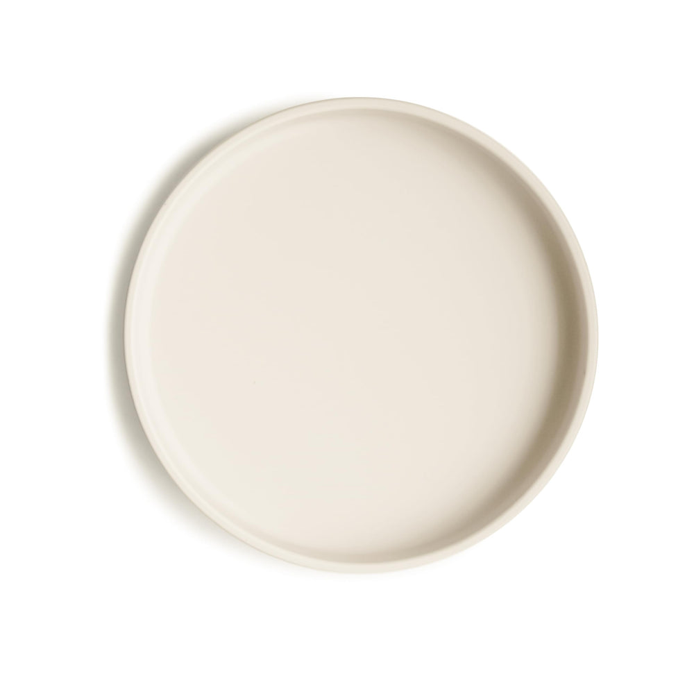 Mushie classic silicone suction plate ivory on table shows secure grip for mess-free meals.