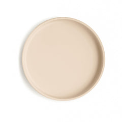 Mushie Classic Silicone Suction Plate on table in shifting sand color, reducing spills during meals