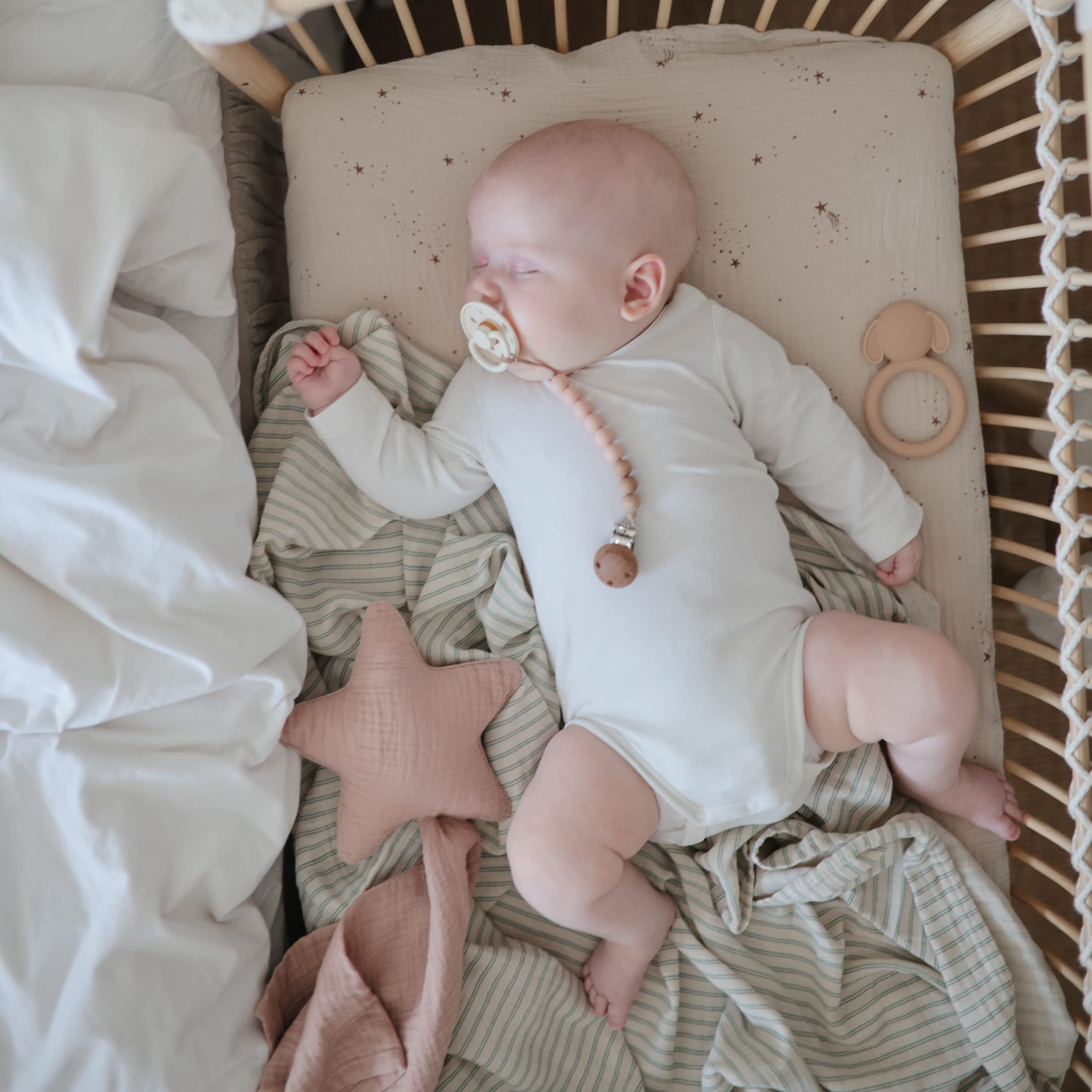 Mushie crib sheet elastic edges closeup showing snug fit on mattress