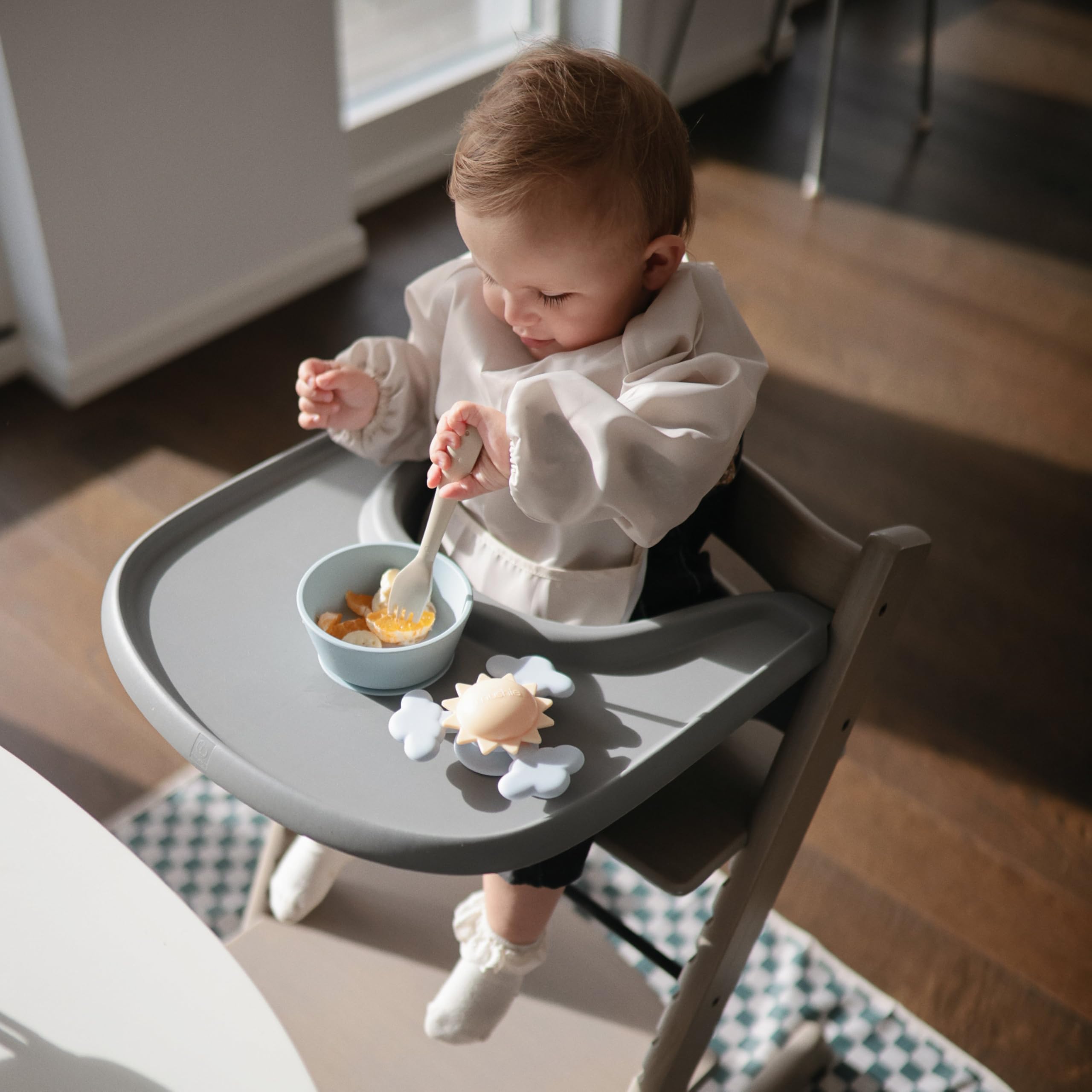 Mushie fork sage held by kid highlights kid-friendly size and control.