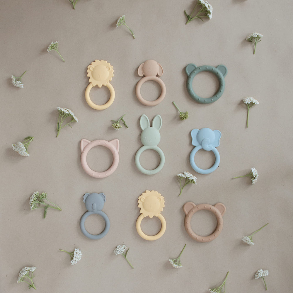 Mushie Dog Brown Teether on blanket shows cozy home-friendly teething accessory