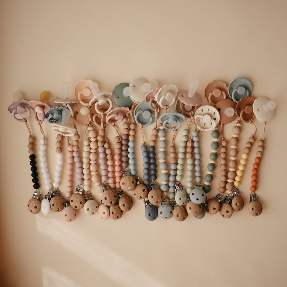 Mushie Eva pacifier clip helps parents keep items in reach while shopping