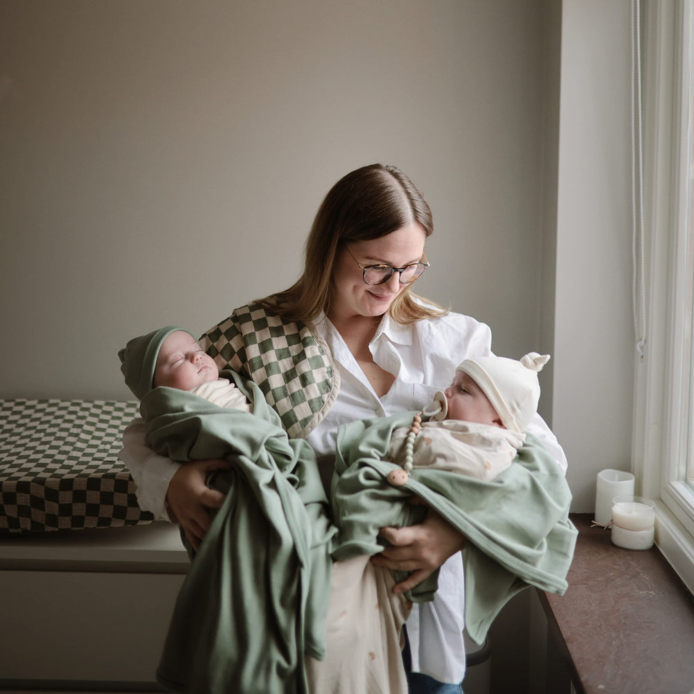 Mushie Roman Green blanket folded for easy travel and storage