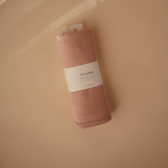 Mushie blanket swaddle-in-use demonstrating gentle stretch