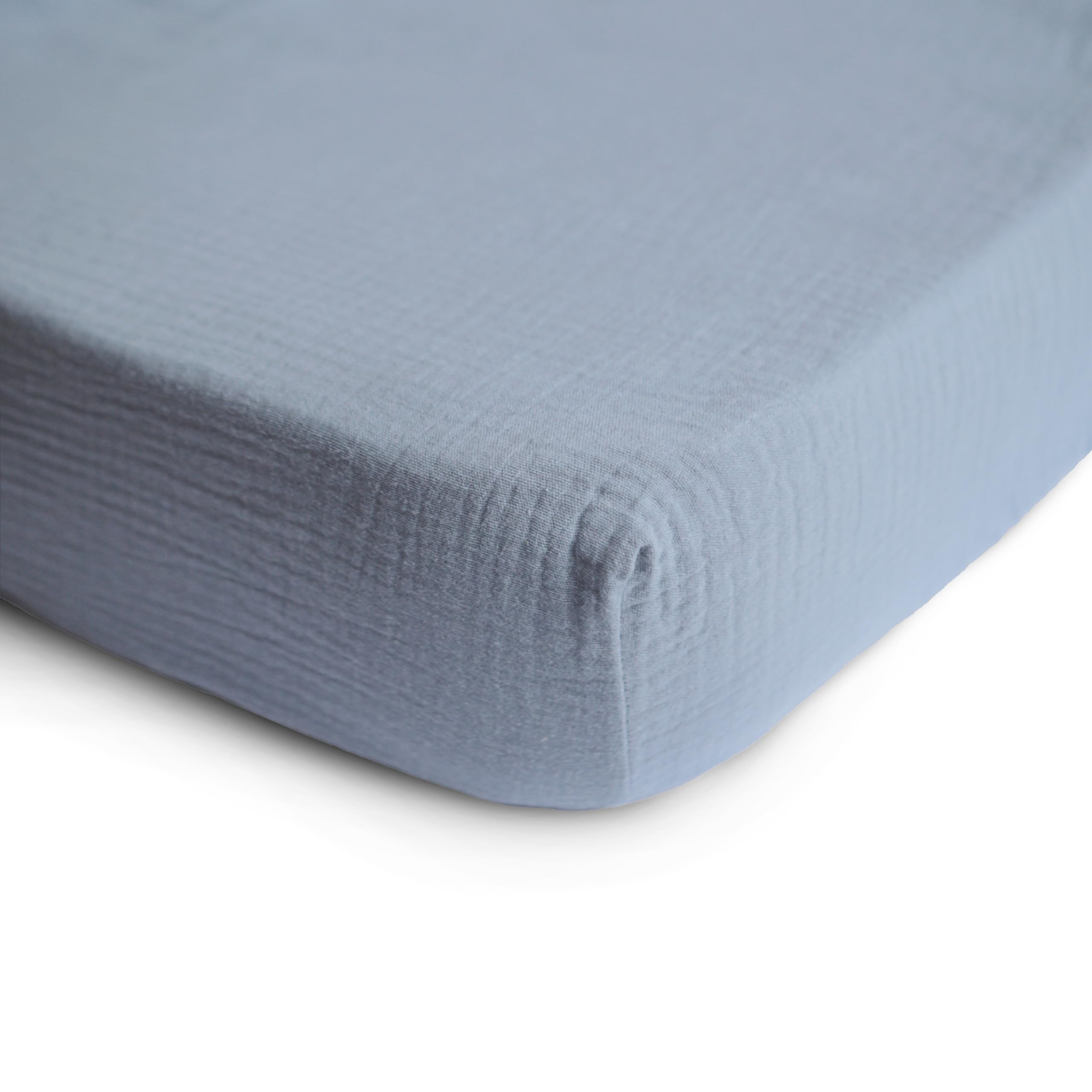 Mushie fitted crib sheet on a mattress shows a snug, secure sleep space.
