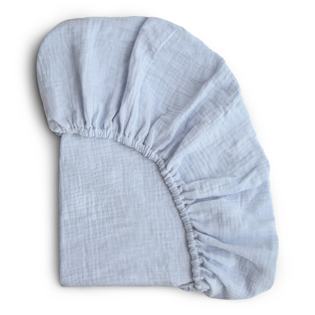 Mushie extra-soft muslin crib sheet baby blue closeup highlighting plush texture for gentle sleep.