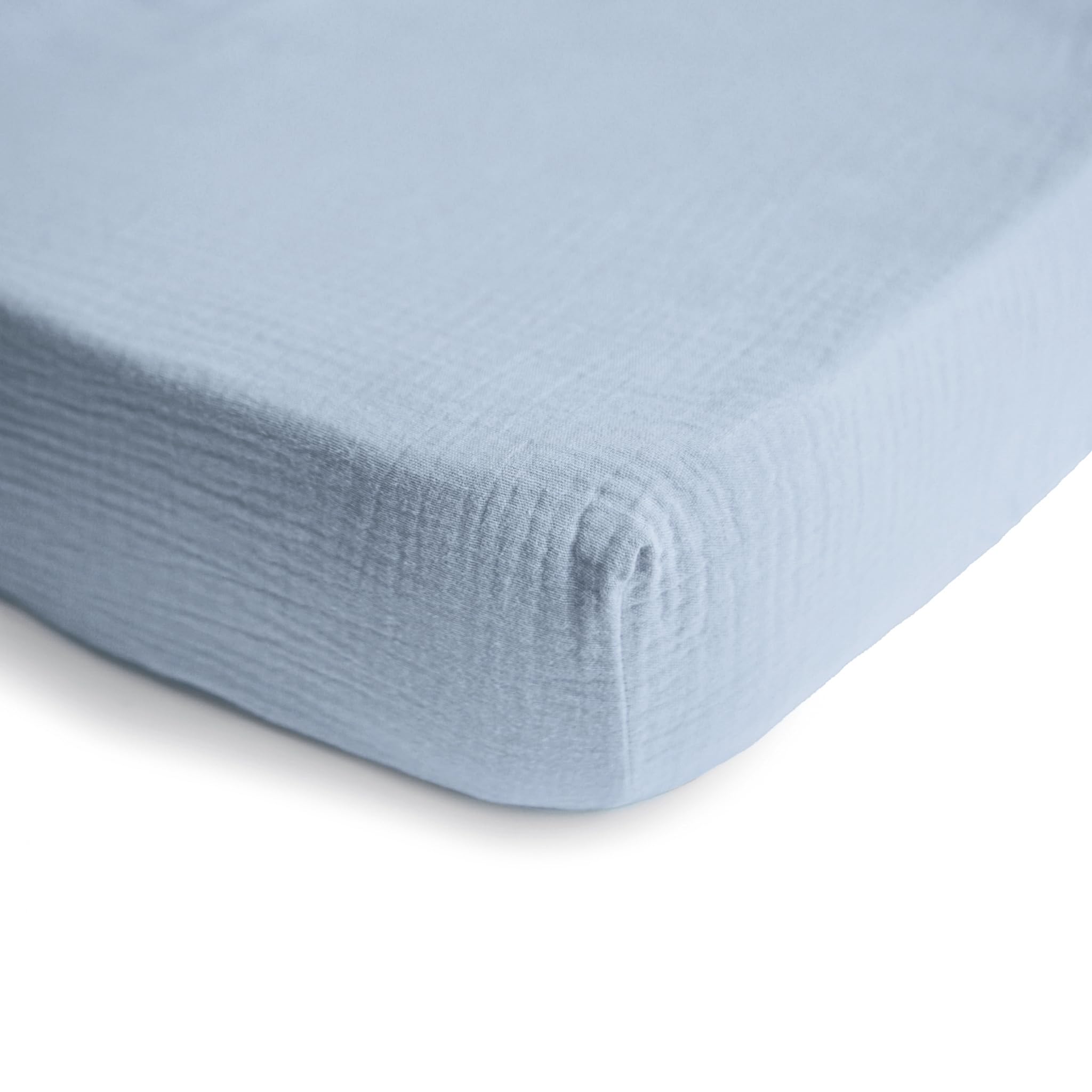 Mushie extra-soft muslin crib sheet baby blue on mattress with snug fit demonstration.