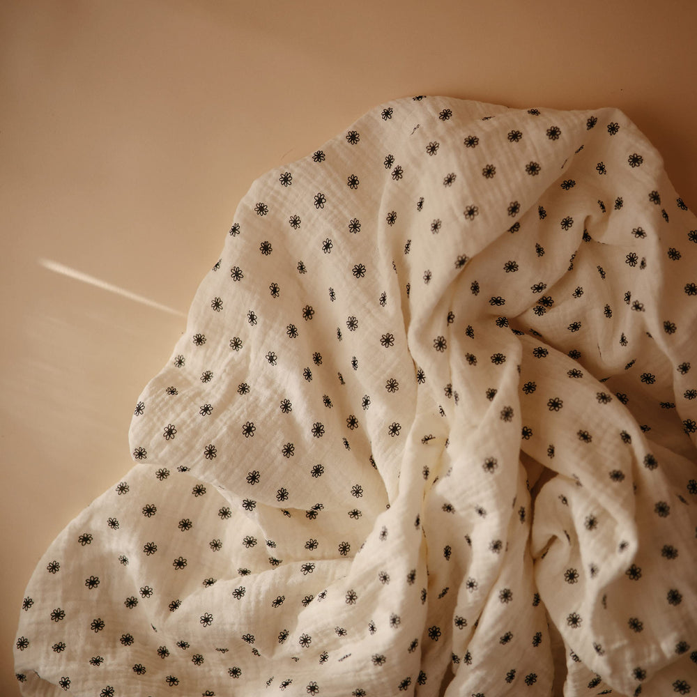 Mushie muslin sheet folded for easy storage and quick changing setups.