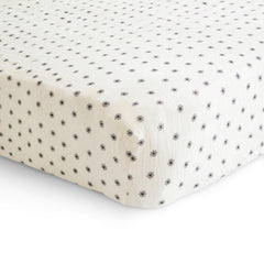Mushie crib sheet on mattress demonstrates snug fit with deep pockets.