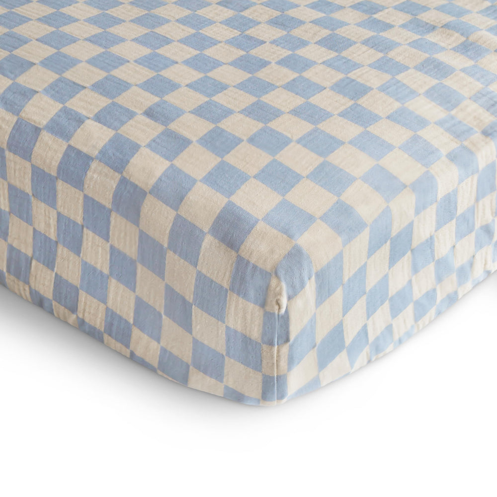Mushie crib sheet elastic edges demonstrate snug fit after wash