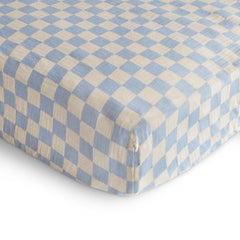 Mushie crib sheet elastic edges demonstrate snug fit after wash