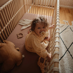 Mushie deep pockets keep the sheet securely in place during baby’s sleep.