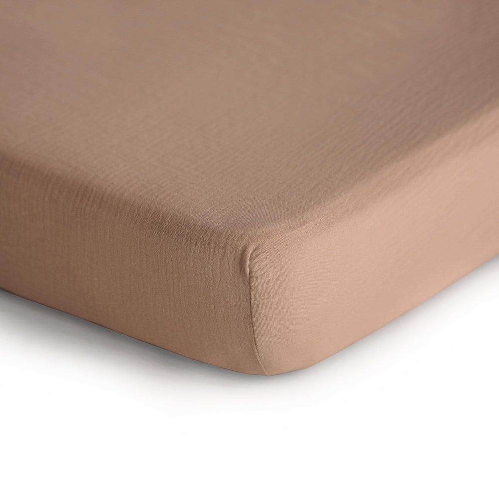 Mushie fitted crib sheet with elastic fit stays snug on standard crib mattresses.