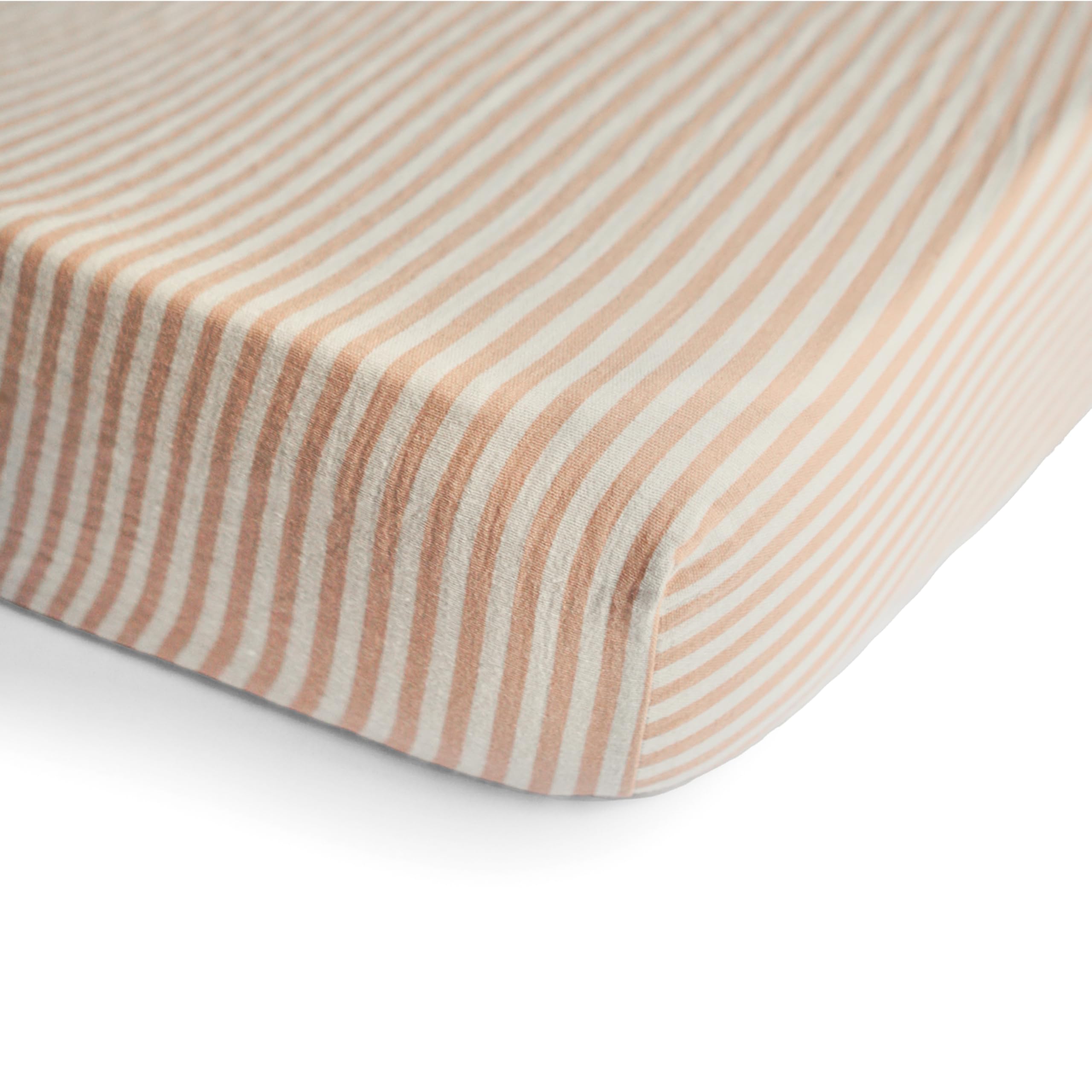 Mushie muslin fitted crib sheet on mattress shows snug fit and deep pockets