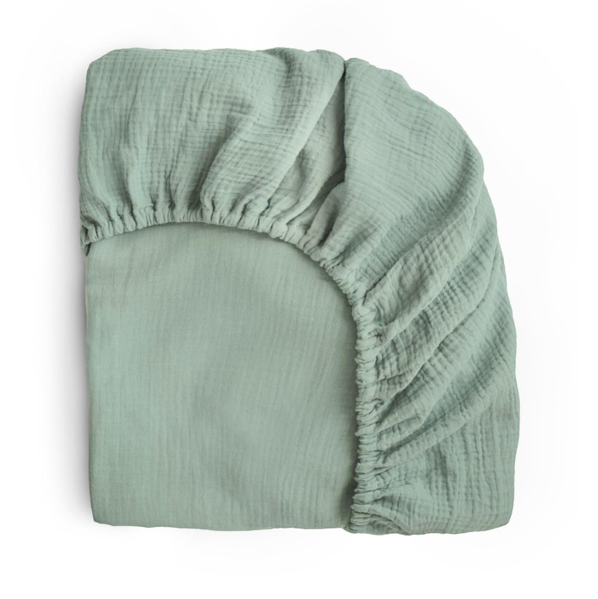 Mushie extra soft muslin crib sheet flatlay in Roman Green highlighting breathable warmth.