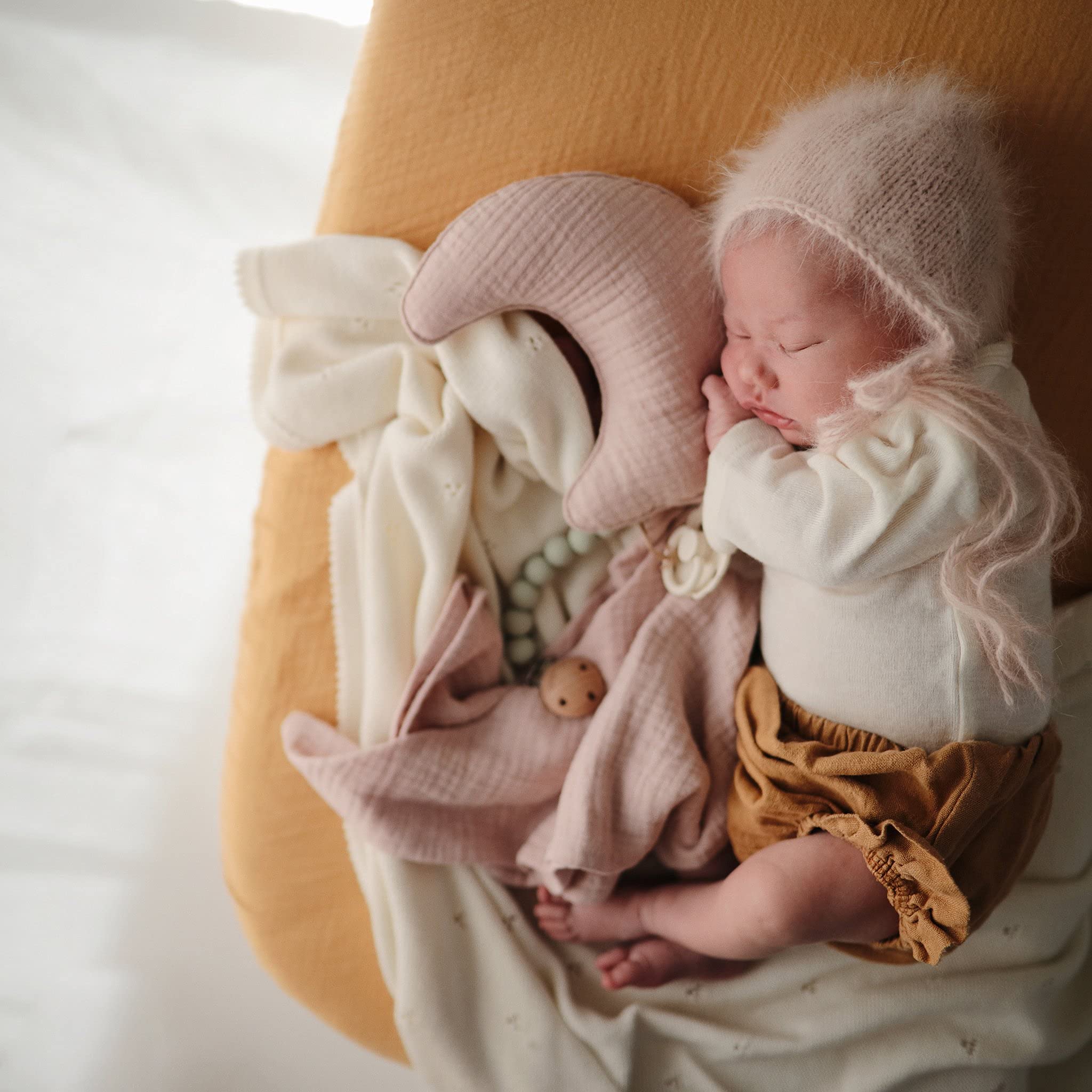 Mushie fitted crib sheet with elastic edge highlights a snug, secure fit.