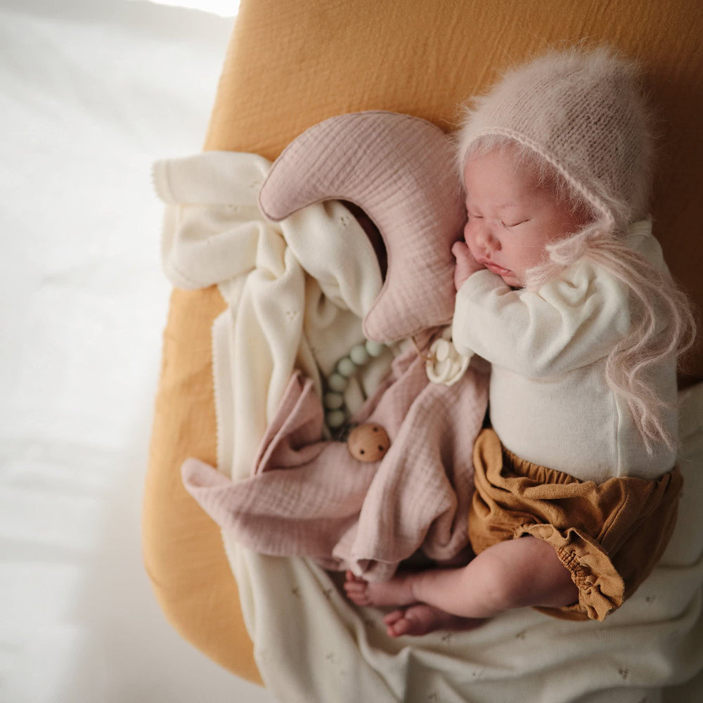 Mushie fitted crib sheet with elastic edge highlights a snug, secure fit.