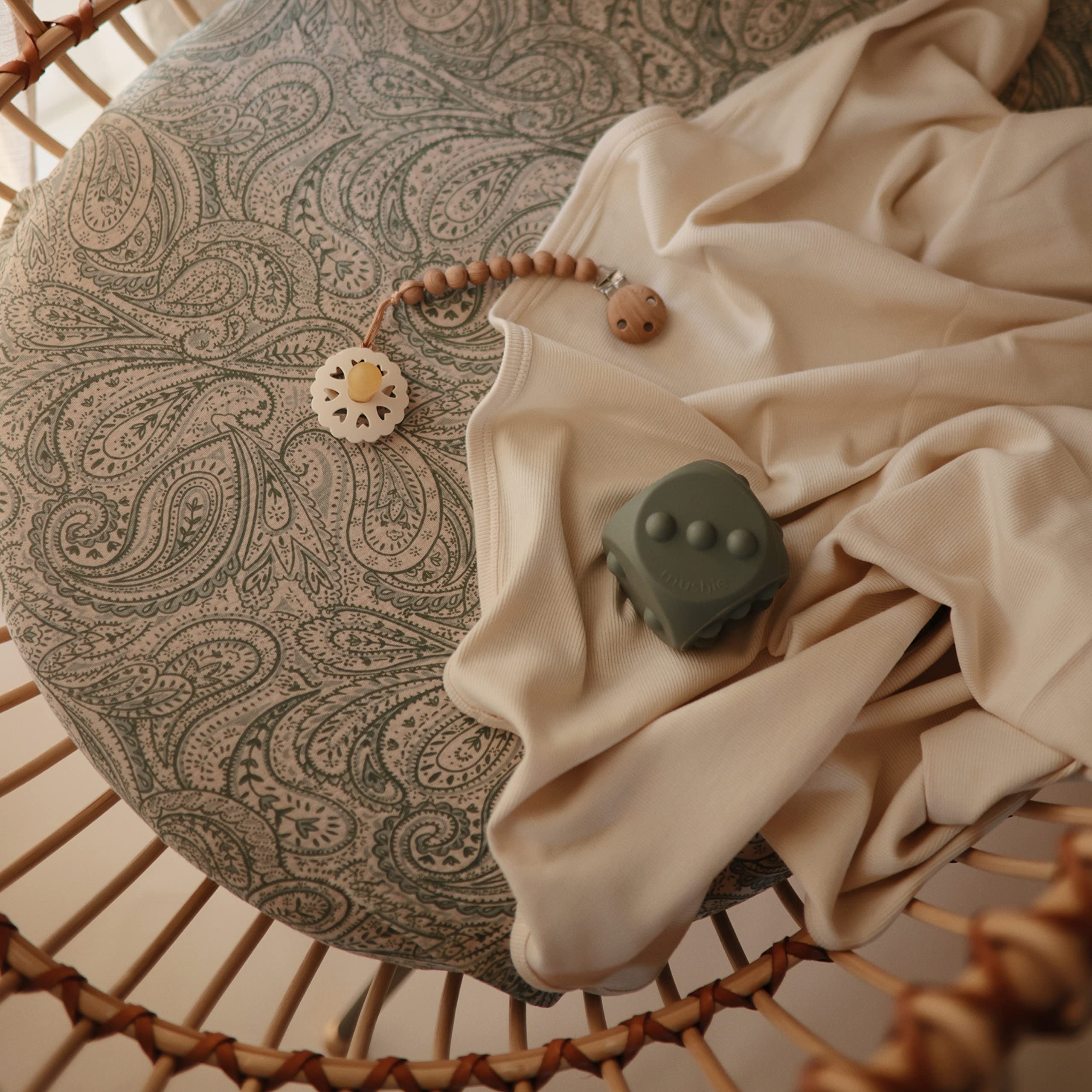 Mushie green paisley design crib sheet emphasizes calming nursery aesthetics.