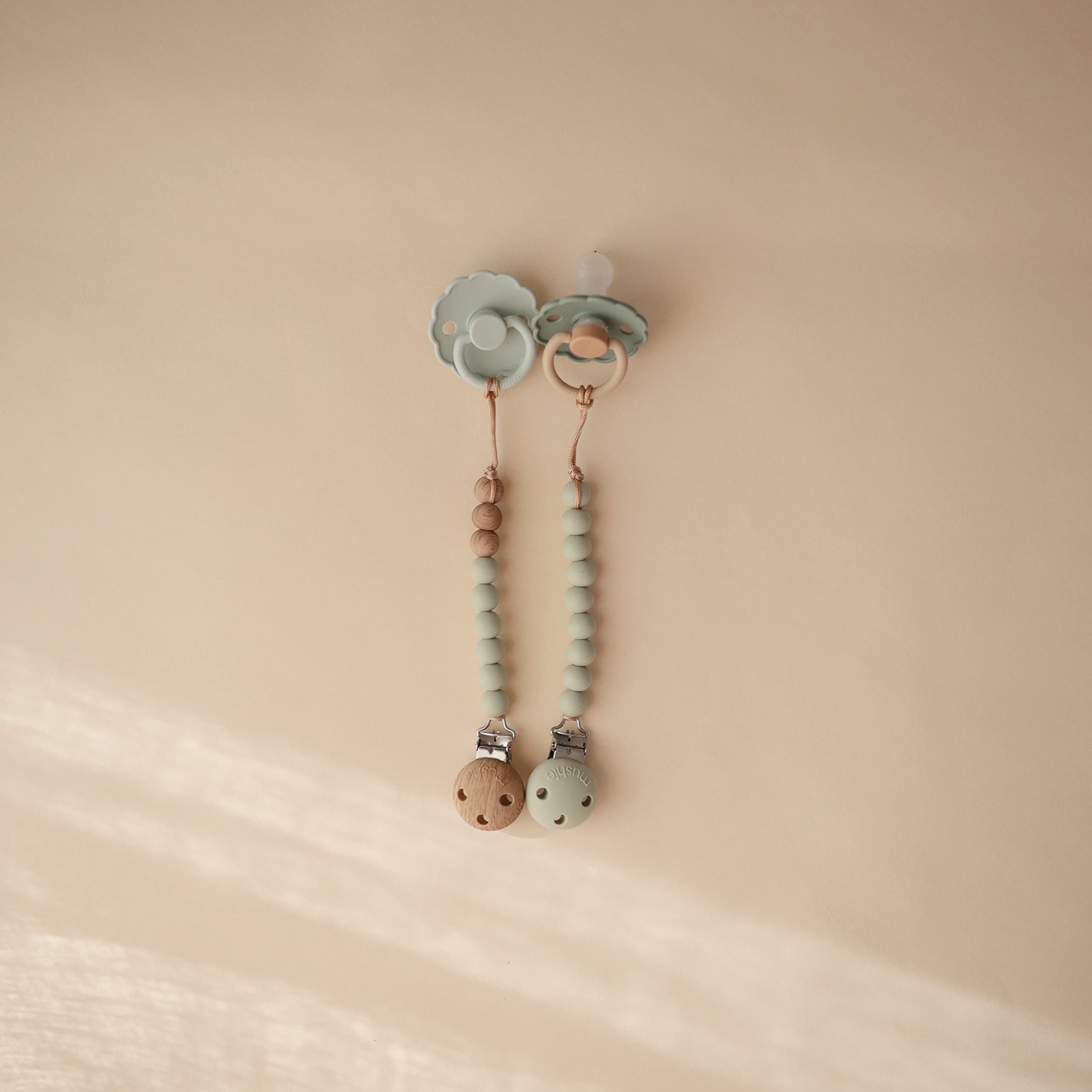Mushie Hera Sage pacifier clip beads stack highlights soft calming colors.