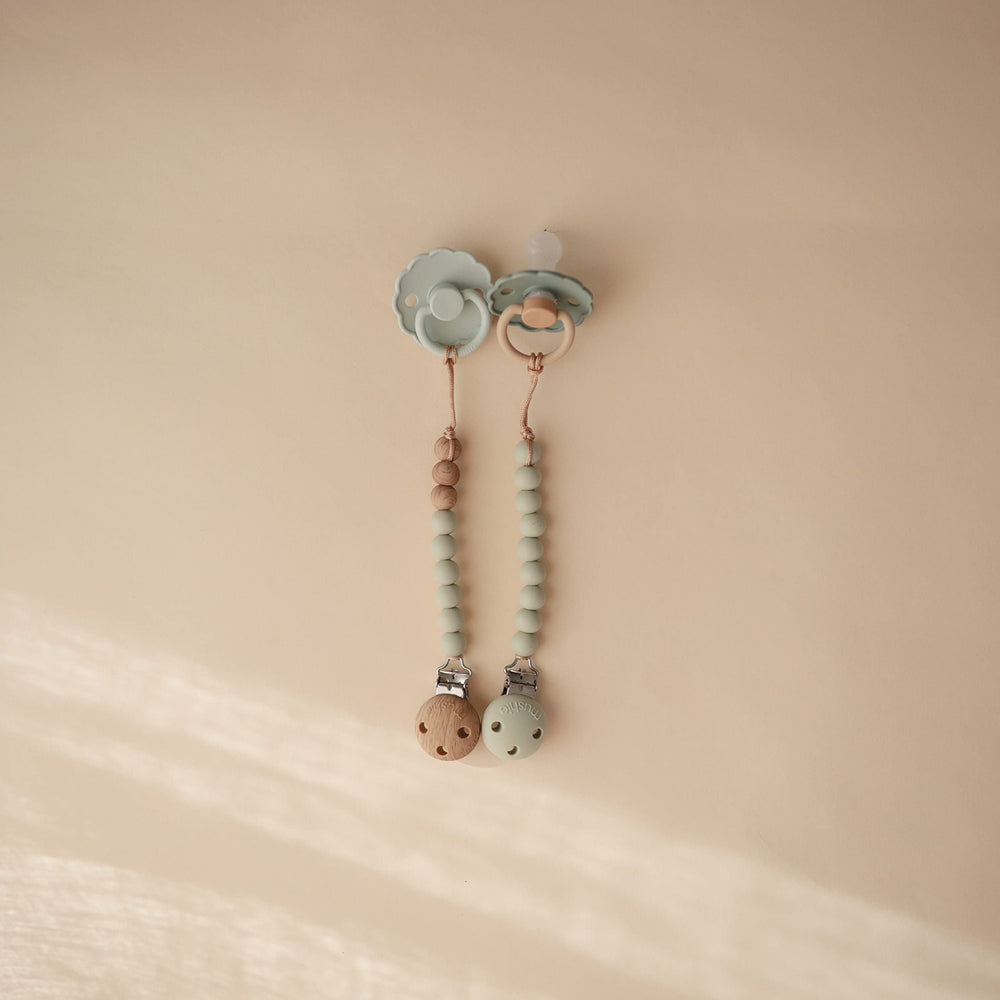 Mushie Hera Sage pacifier clip beads stack highlights soft calming colors.