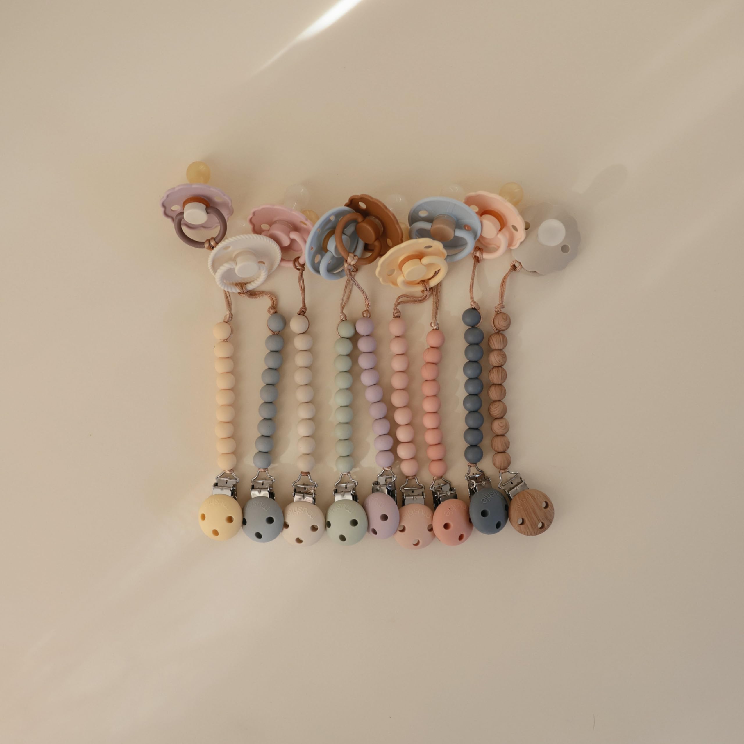 Mushie Hera Sage pacifier clip care instructions for hand washing.