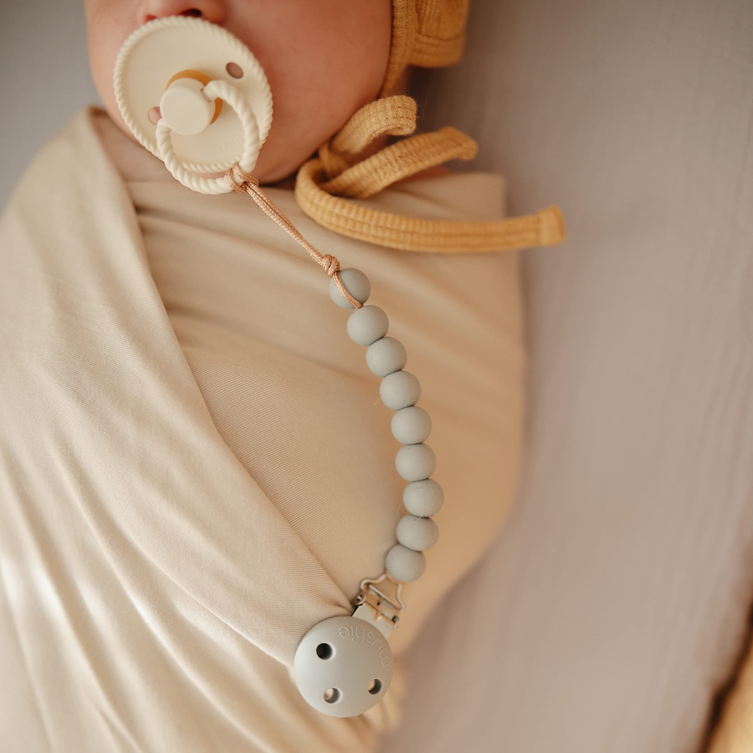 Mushie Hera Sage pacifier clip eight-inch length for everyday wear.