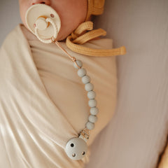 Mushie Hera Sage pacifier clip eight-inch length for everyday wear.