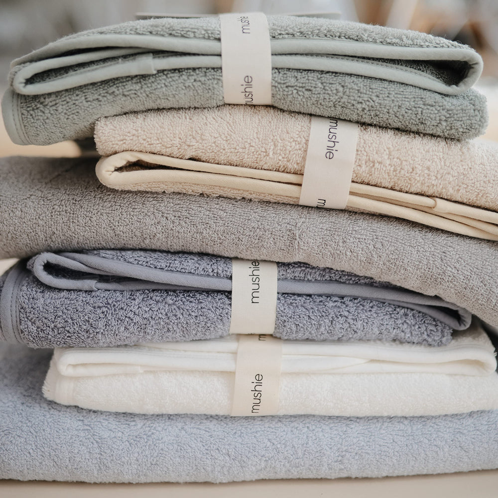 Mushie hooded towel blue flat lay highlighting color and size