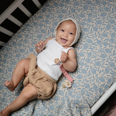 Mushie linen pacifier clip Shifting Sand closeup showing soft fabric and durable loop design.