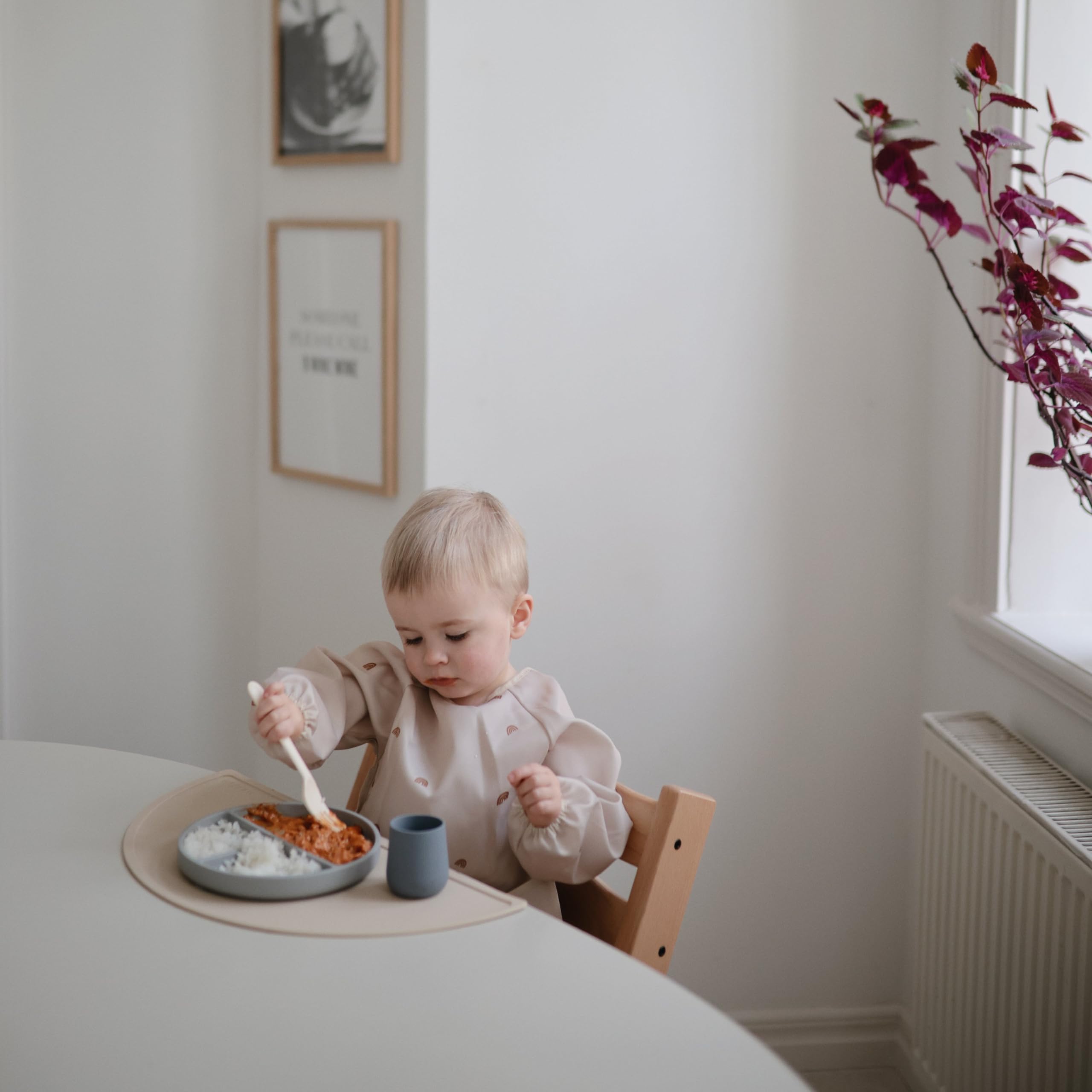 Mushie Rainbows bib demonstrates wipe-clean surface and quick cleanup after meals.