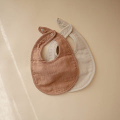 mushie muslin bib adjustable snaps demonstrate growing baby fit