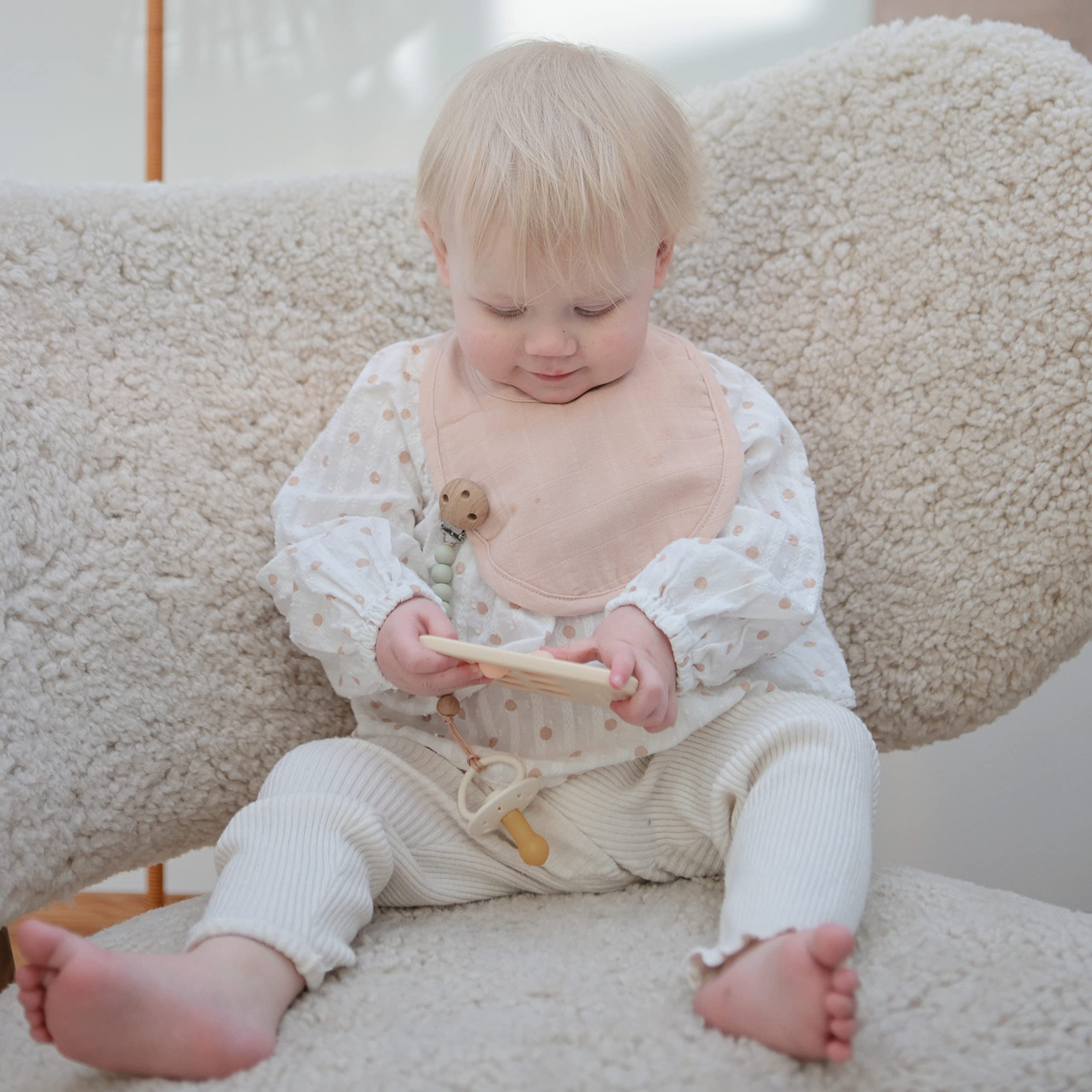 Mushie muslin bib baby-wearable comfortable for 0–24 months during everyday feedings.