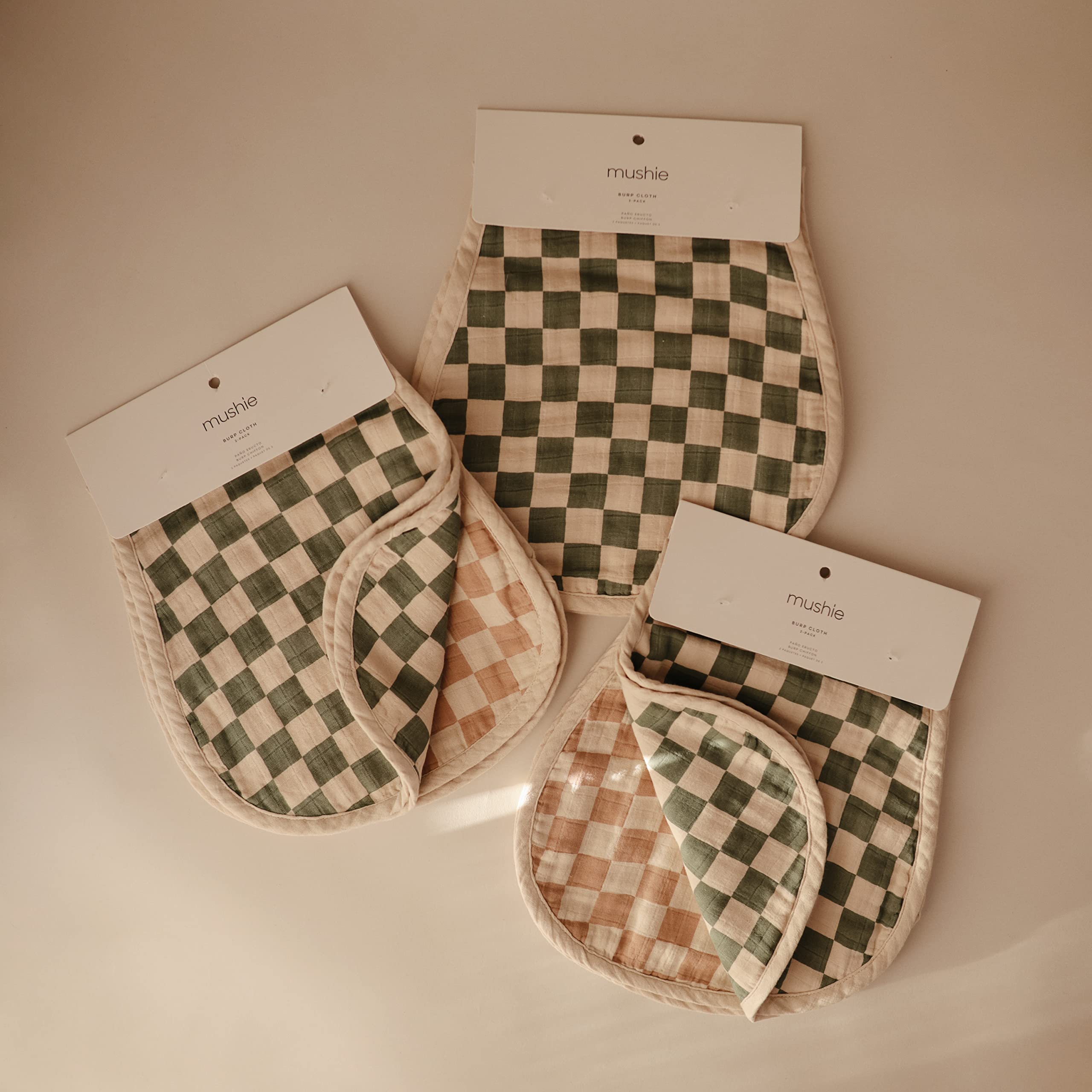 Mushie muslin burp cloth in natural check laid flat, lightweight and breathable for everyday care.