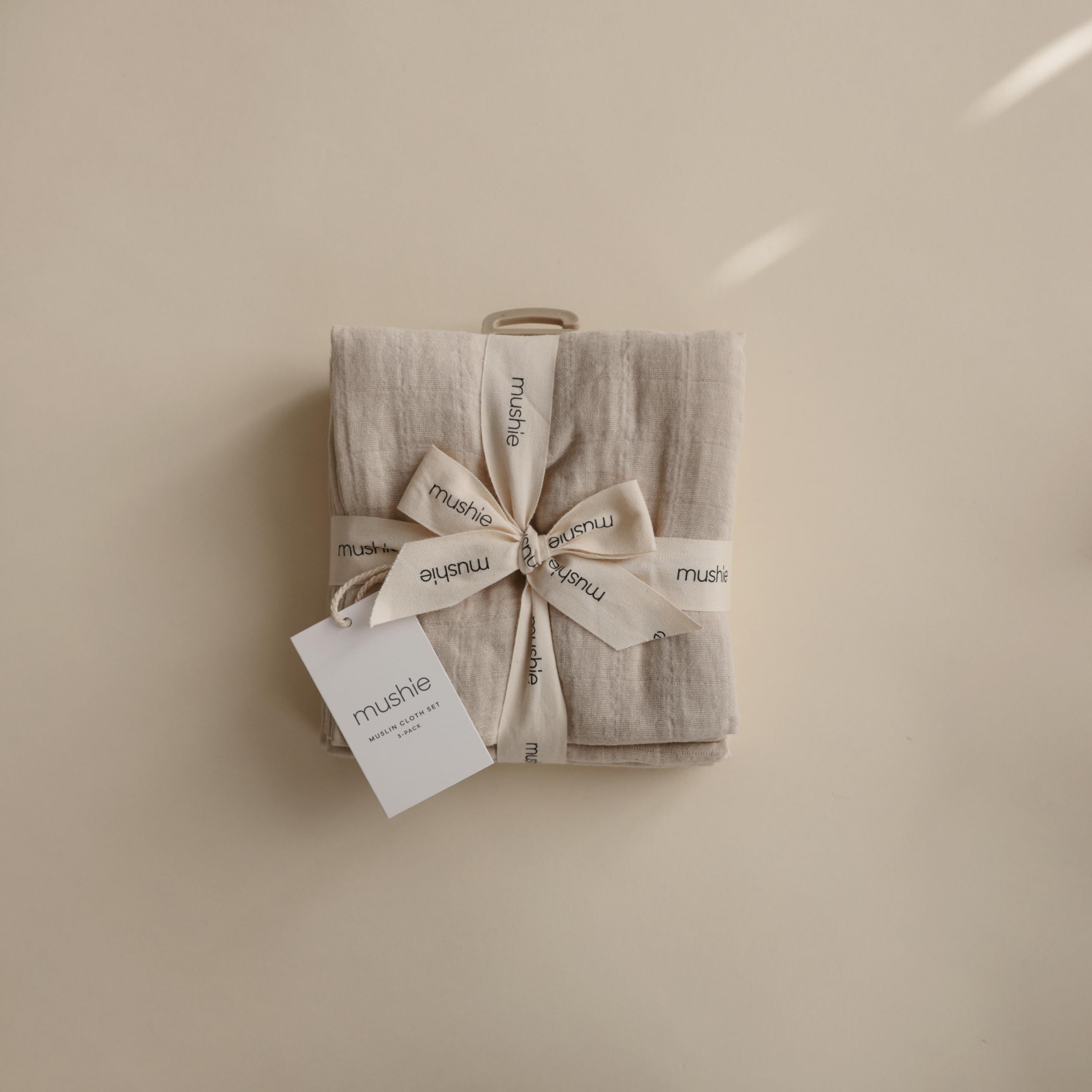 Mushie Muslin Cloth Fog in-use-with-baby conveys cozy nursery companion
