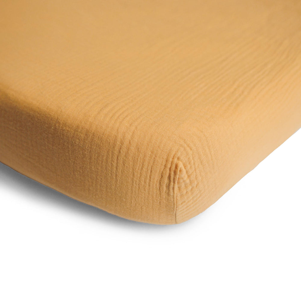 Mushie muslin crib sheet shown soft and pre-washed for immediate gentle-touch against delicate skin.