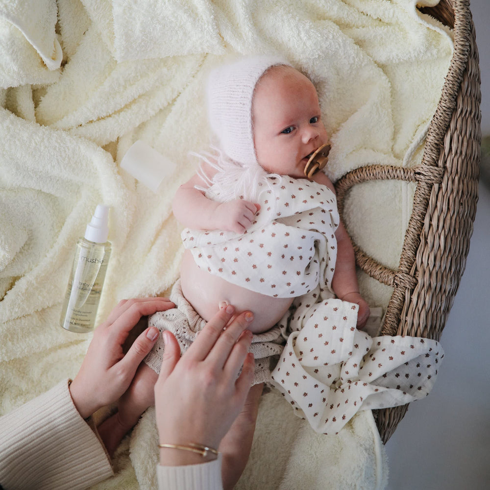 Mushie Organic Baby Oil on baby soft skin demonstrates skin-softening hydration for daily use.