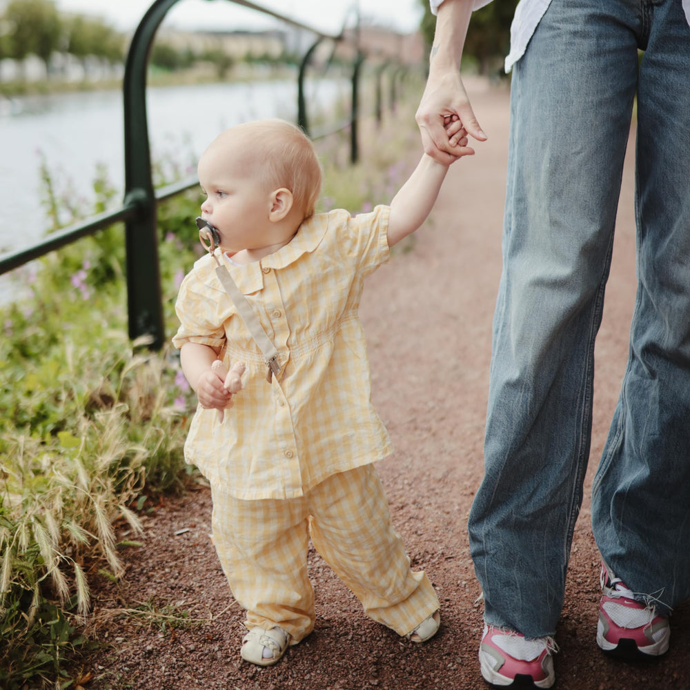 Mushie pacifier clip stroller use demonstrating travel-ready convenience.