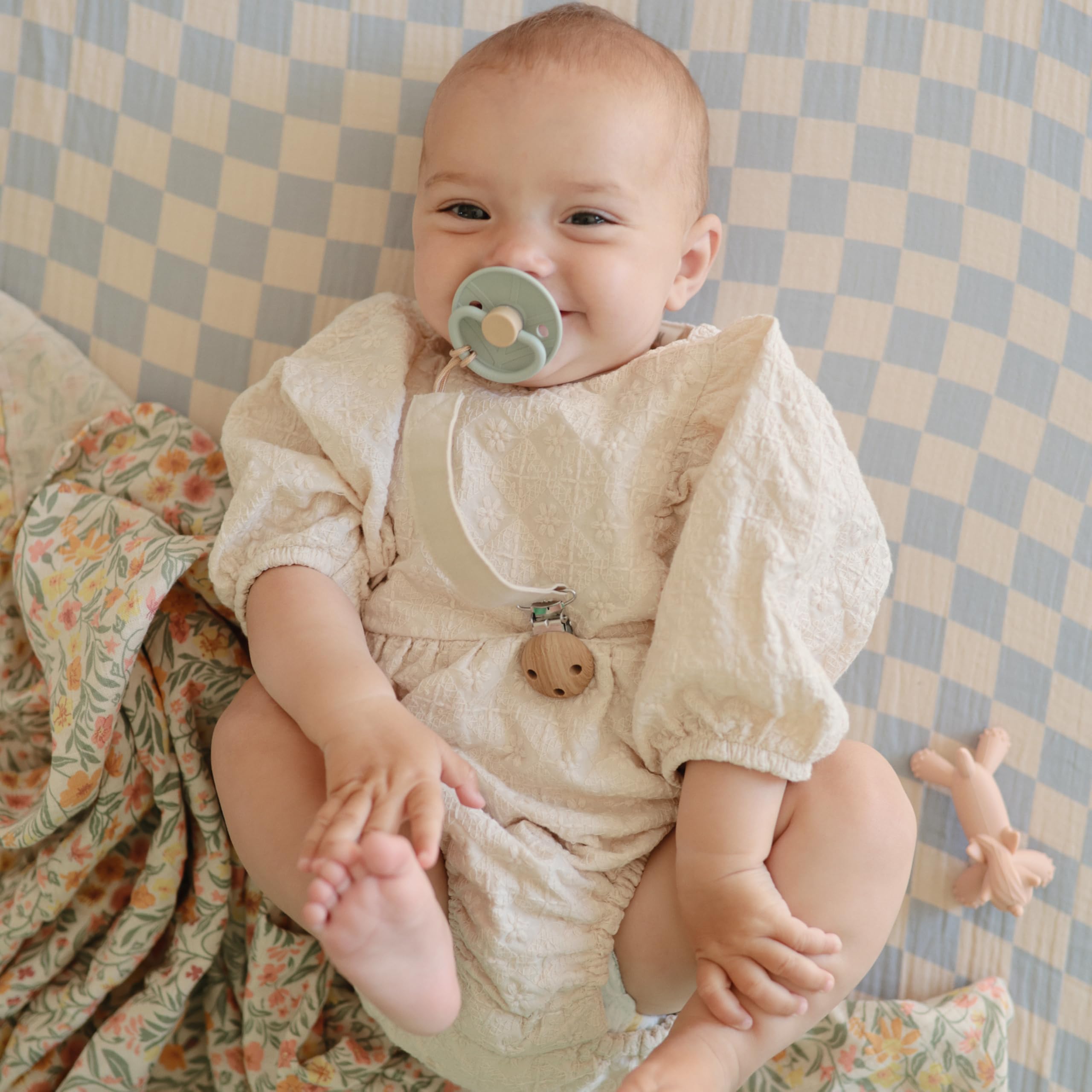 Mushie pacifier clip with water-resistant coating for daily messes.