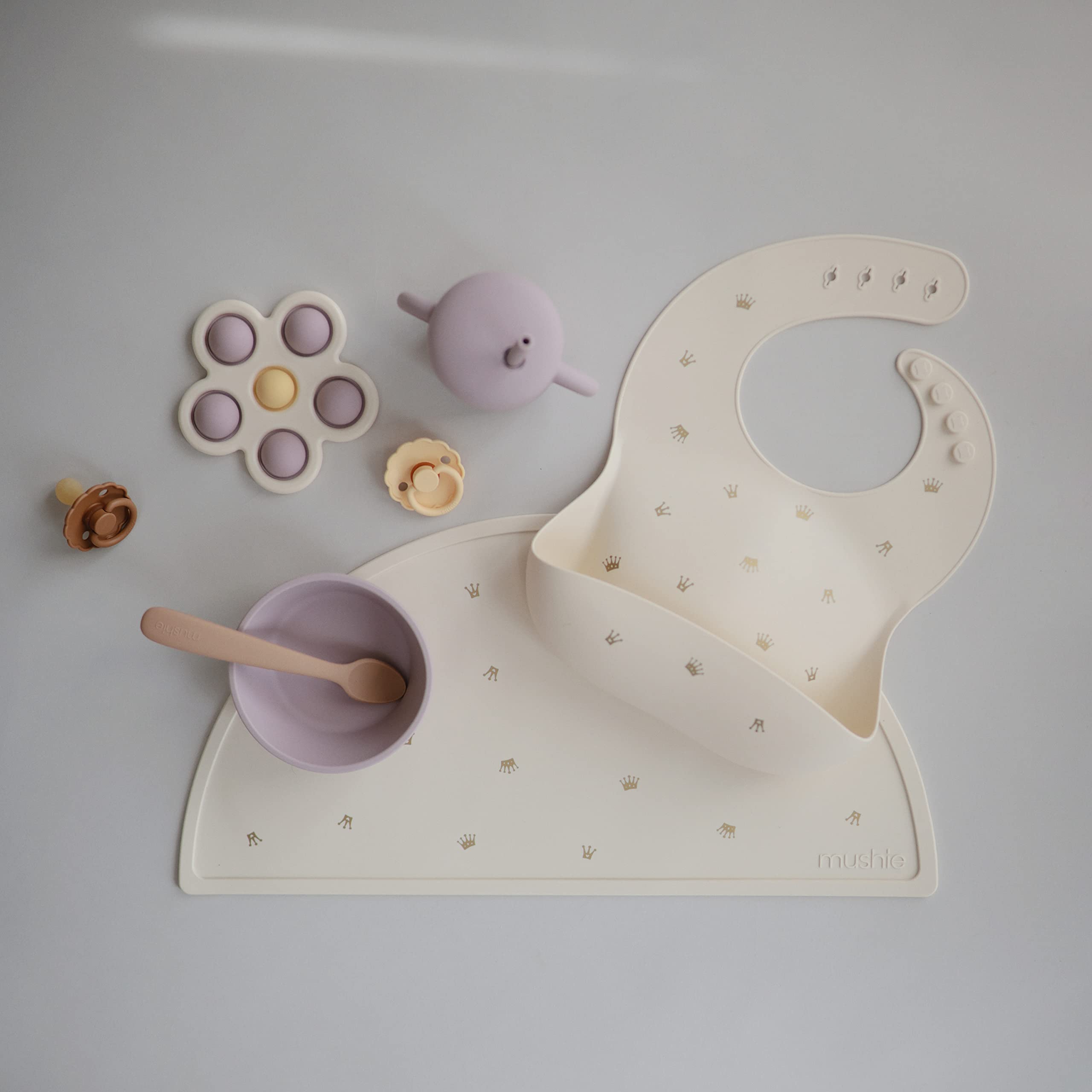 Mushie placemat crowns non-absorbent surface resists stains and wipes clean.