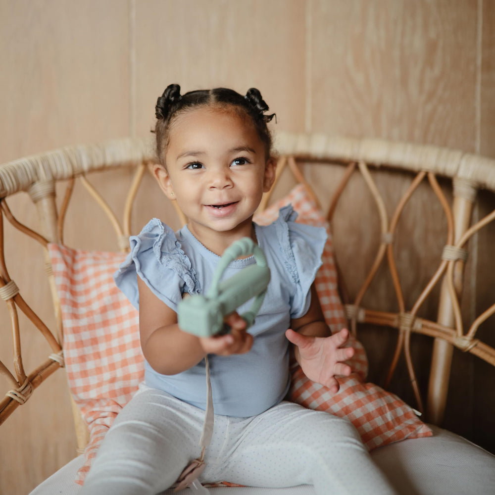 Mushie robot rattle teether in-use view captures curious infant engagement