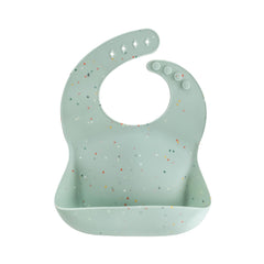 Mushie silicone baby bib with adjustable neck-closure catches spills during meals.