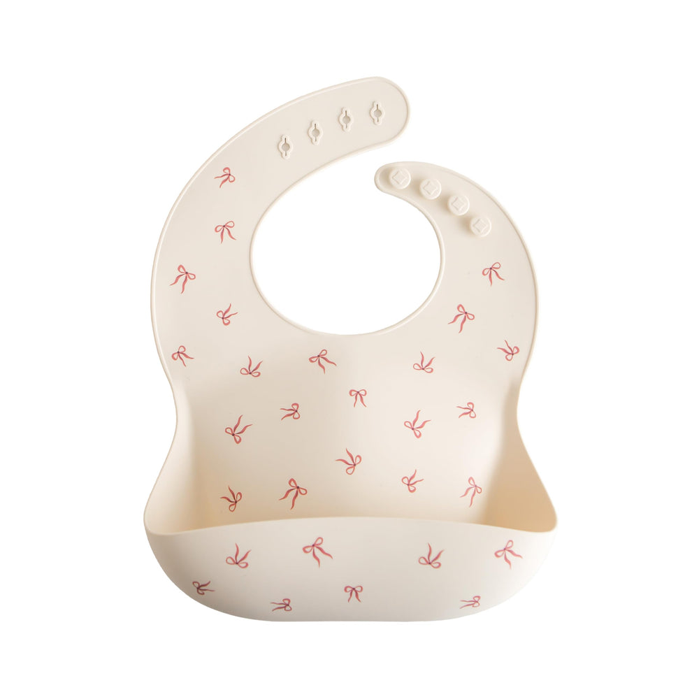 Mushie silicone baby bib with adjustable neck-fasteners for a snug growing fit during meals