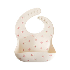 Mushie silicone baby bib with adjustable neck-fasteners for a snug growing fit during meals