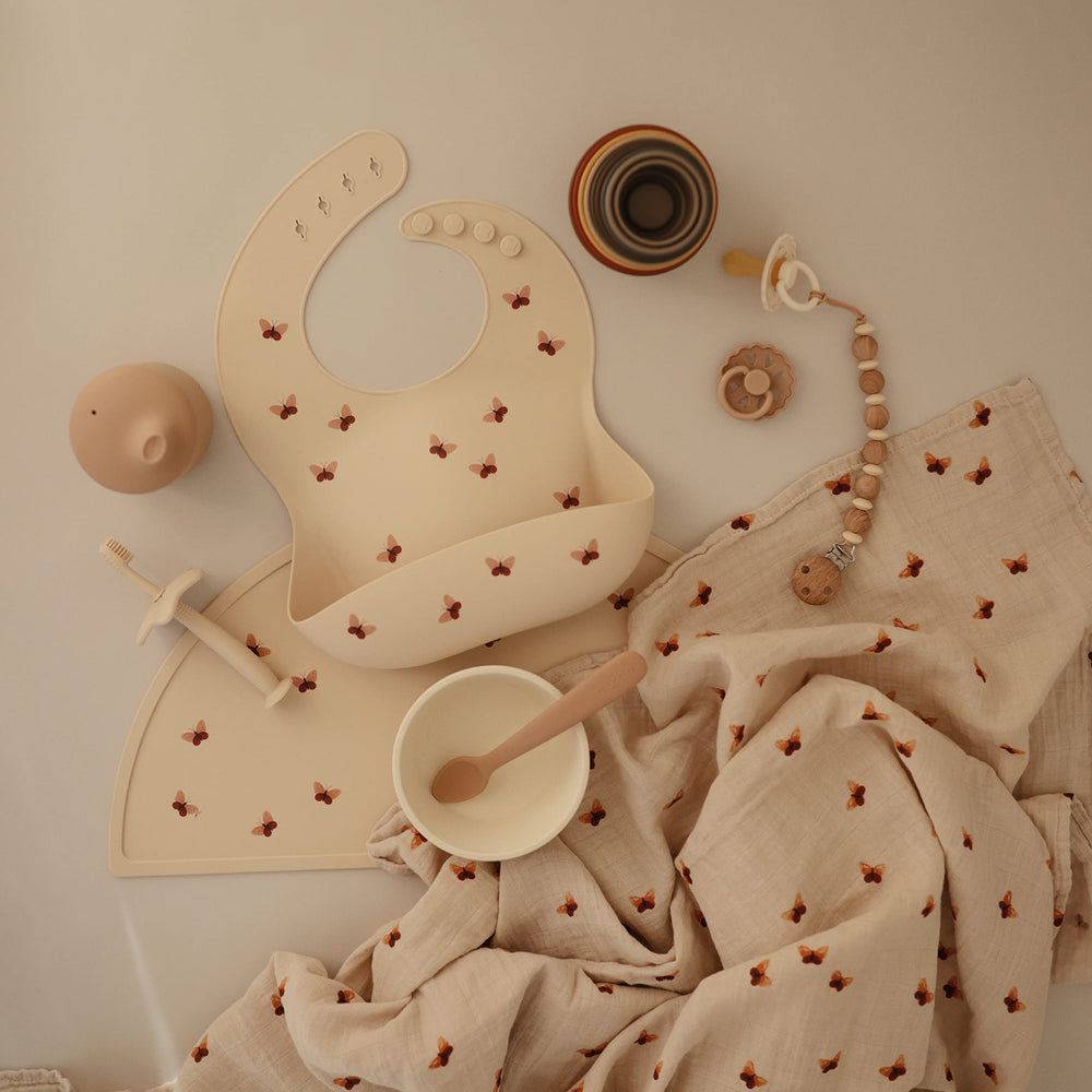 Mushie butterfly bib closeup highlights stain-resistant surface