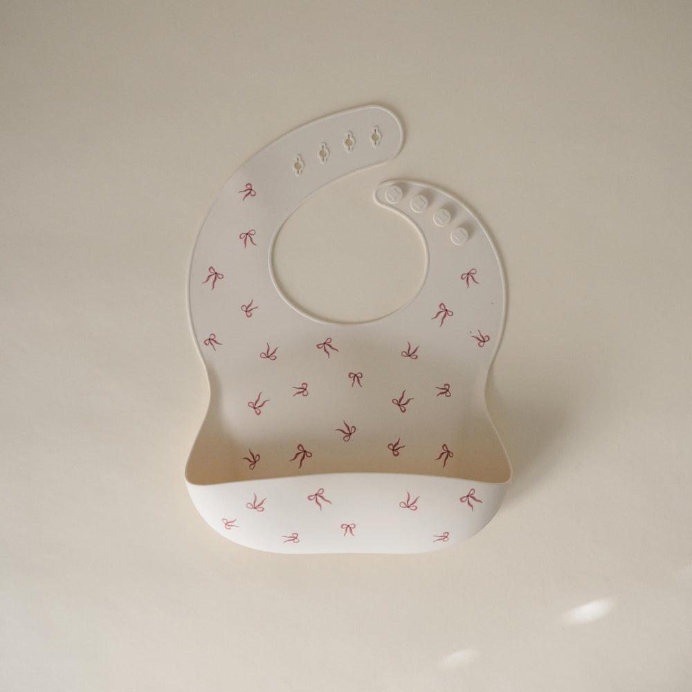 Mushie silicone baby bib with a deep pocket to catch crumbs and reduce mess