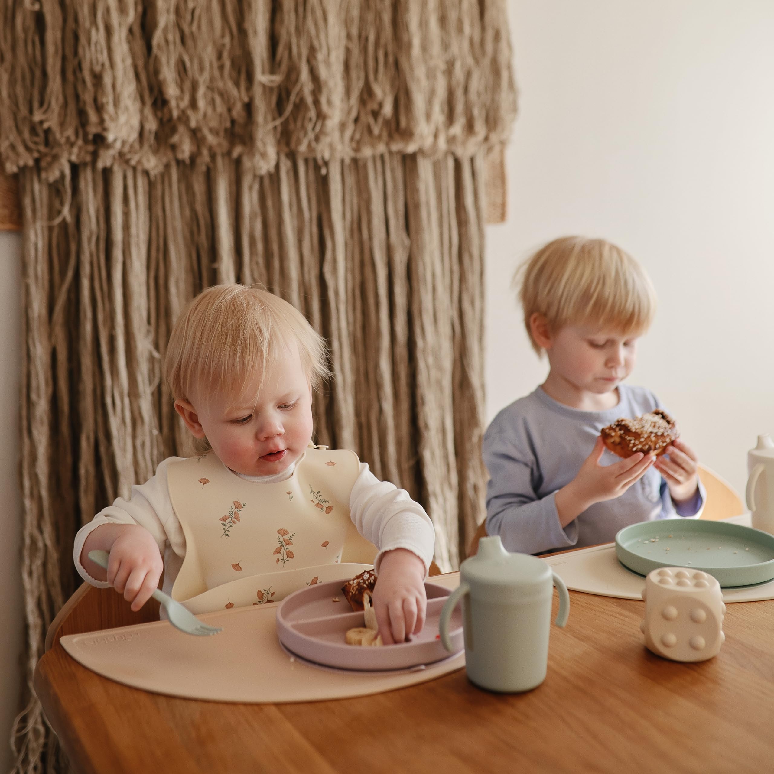 Mushie pink flowers bib waterproof surface keeps mealtime surfaces drier