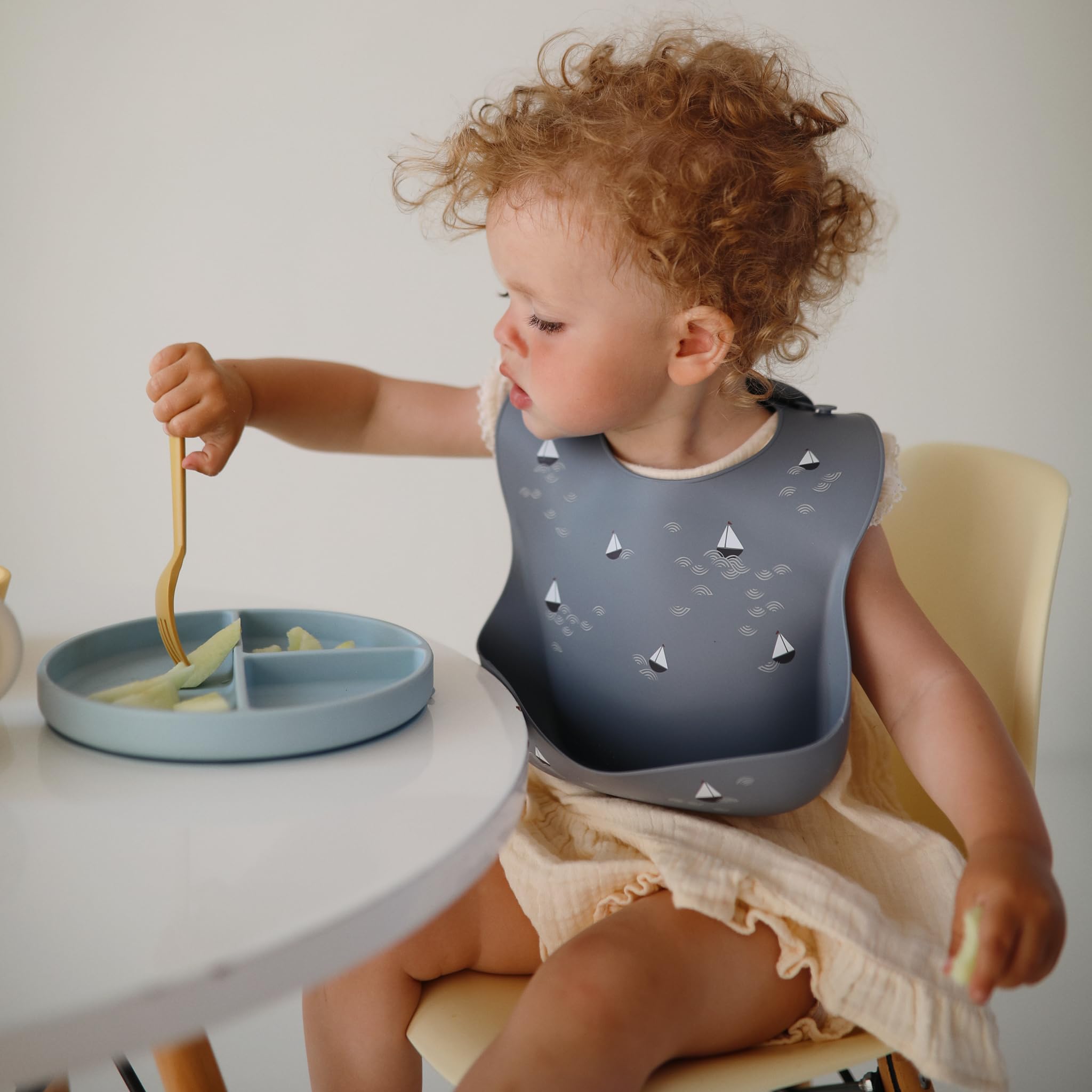 Mushie Planets bib color and pattern close-up for stylish spill-proof feeding.